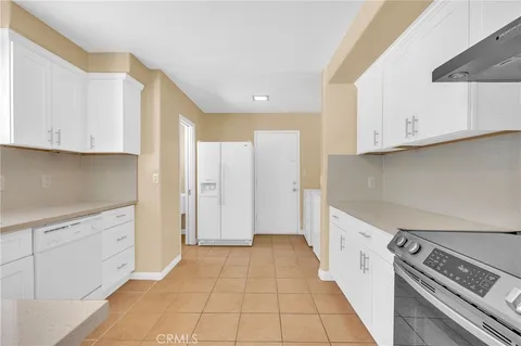 a kitchen with granite countertop white cabinets and a sink