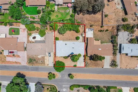 an aerial view of a house with a yard and garden in the back