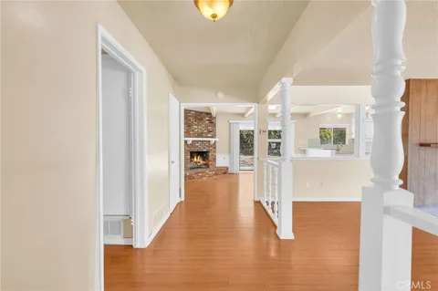 a view of a hallway with wooden floor and a living room