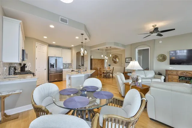 a living room with furniture kitchen view and a chandelier