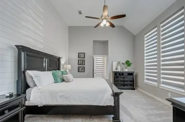 a bedroom with a large bed and a chandelier
