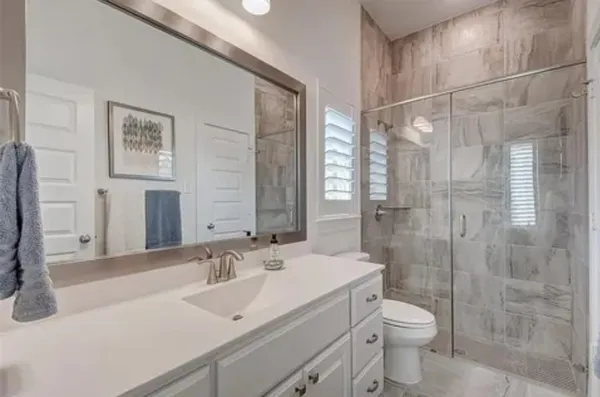 a bathroom with a sink a toilet and shower