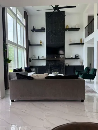 a living room with furniture a large window and kitchen view