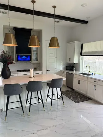 a kitchen with stainless steel appliances kitchen island a table chairs in it and wooden floors