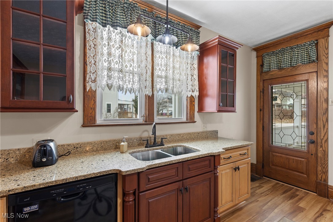 1011 Parriott Avenue Moundsville, WV 26041 - Photo 11 of 44 Kitchen with glass insert cabinets, dishwasher, light stone counters, hanging light fixtures, and light wood-type flooring