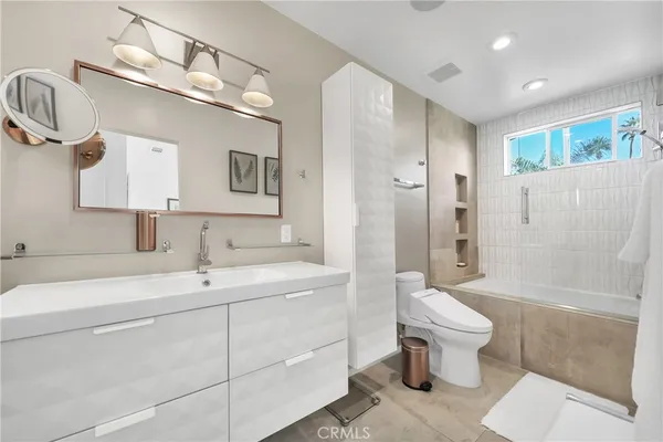 a bathroom with a sink toilet a mirror and shower