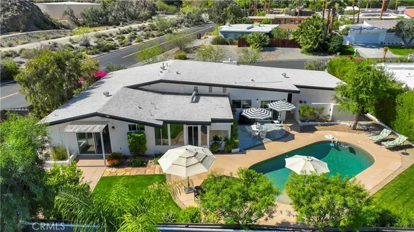 an aerial view of a house with swimming pool patio and outdoor seating