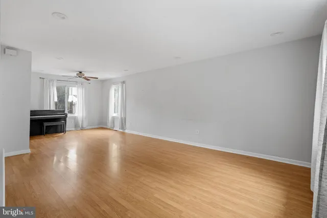 a view of empty room with wooden floor and fireplace