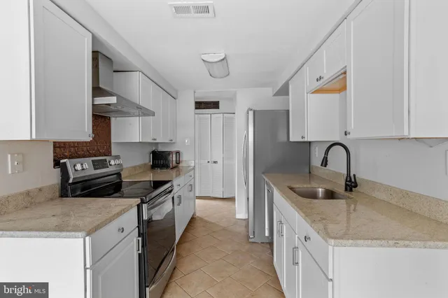 a kitchen with granite countertop a sink and a stove