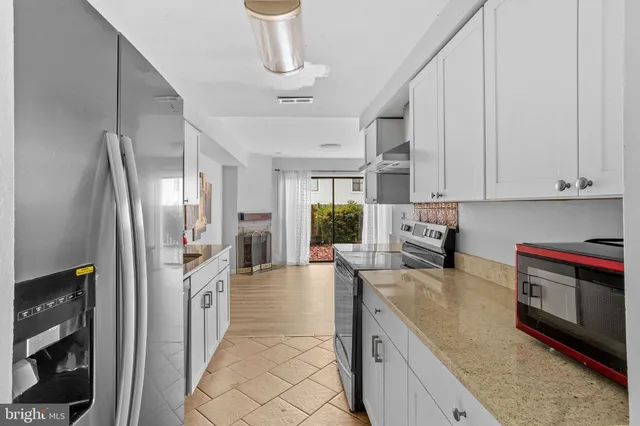 a kitchen with stainless steel appliances granite countertop a sink a stove and a refrigerator