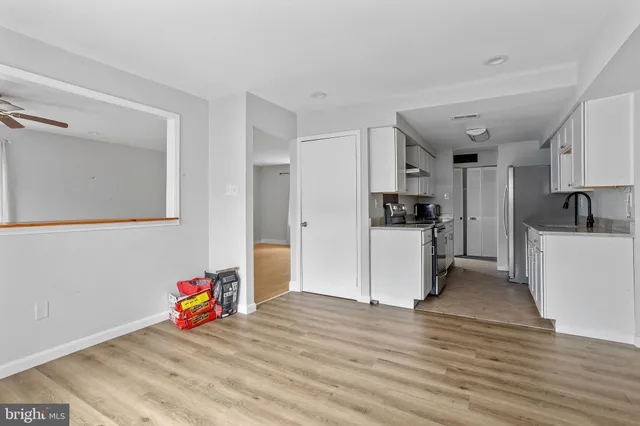 a view of a kitchen with a stove wooden cabinets and wooden floor