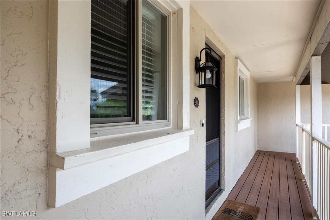 16620 Partridge Place Road, Unit 202 Fort Myers, FL 33908 - Photo 17 of 27 a view of a hallway with wooden floor and windows