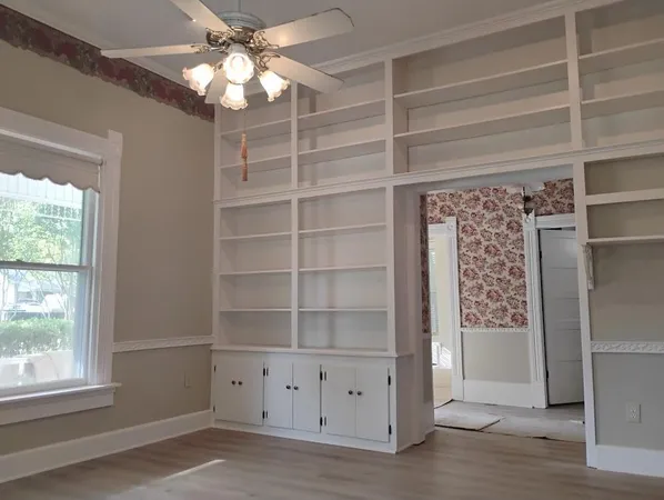 a view of an empty room with a window and a ceiling fan