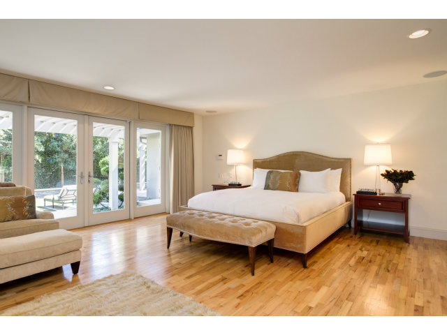 1021 Ocean Road Pebble Beach, CA 93953 - Photo 10 of 25 a bedroom with a bed and wooden floor