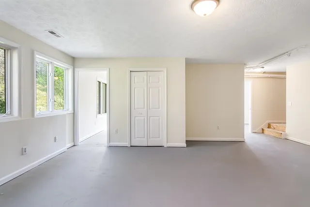 an empty room with windows and closet