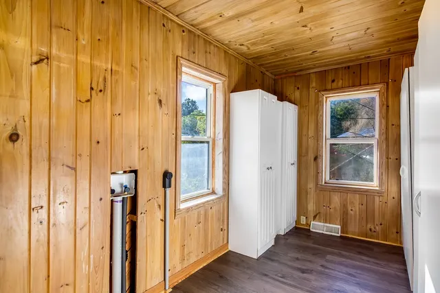 a view of a hallway with wooden floor and windows