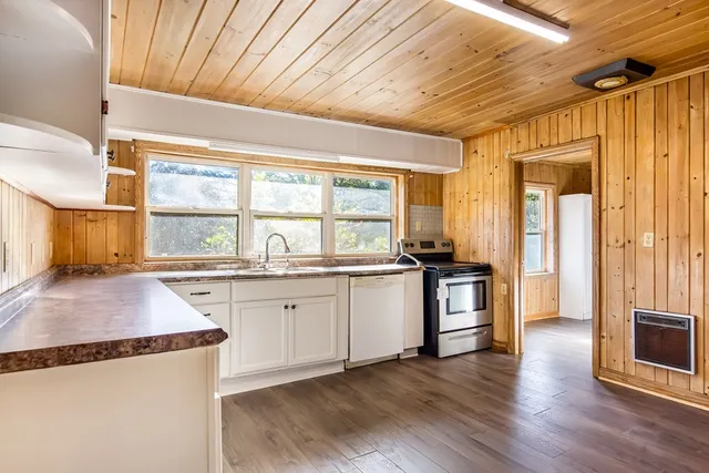 a kitchen with granite countertop wooden floors and wide window
