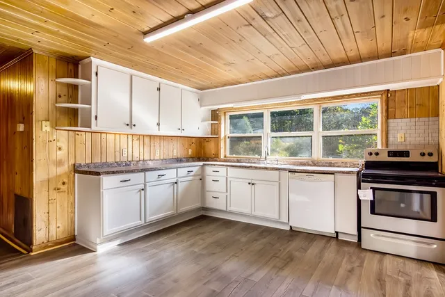 a kitchen with granite countertop cabinets stainless steel appliances and a wooden floor