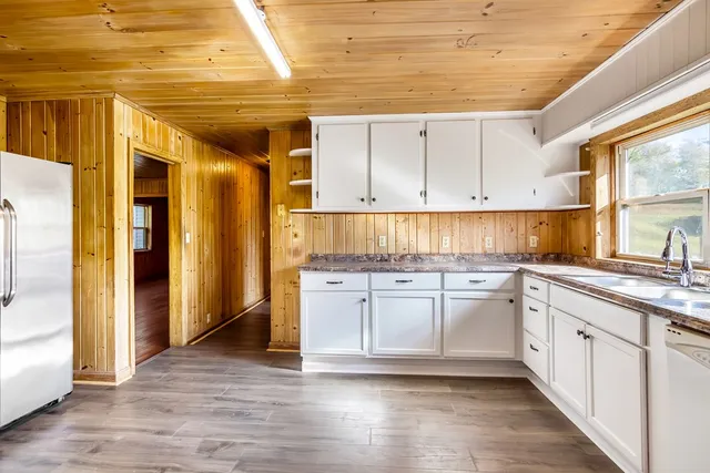 a kitchen with granite countertop white cabinets and white appliances