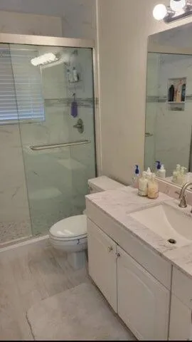 a bathroom with a sink a toilet and shower