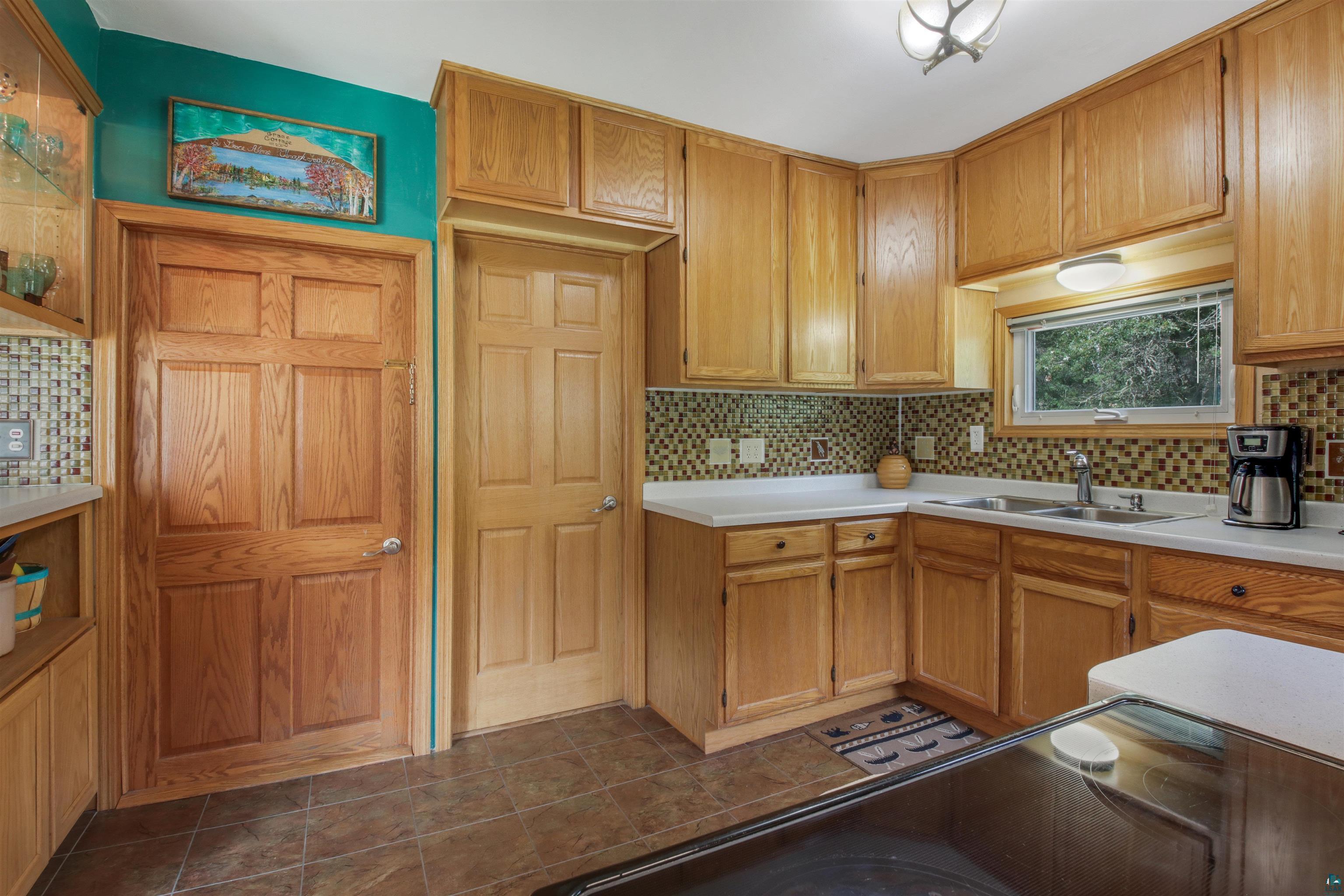 N8348 Island Lake Road Spooner, WI 54801 - Photo 16 of 40 Kitchen with dark tile patterned floors, backsplash, and sink