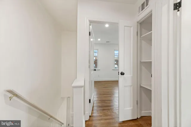 a view of a hallway with wooden floor and staircase