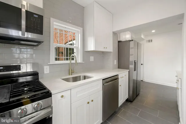 a kitchen with stainless steel appliances granite countertop a sink and a stove