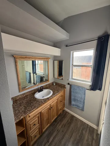 a bathroom with a granite countertop sink and a mirror