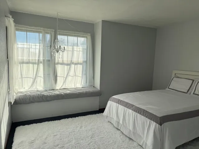 a bedroom with a bed and a window