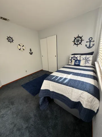 a bedroom with a bed and a painting on the wall