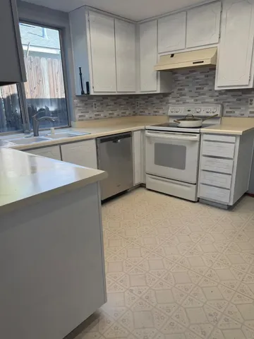 a kitchen with cabinets appliances a sink and a counter top