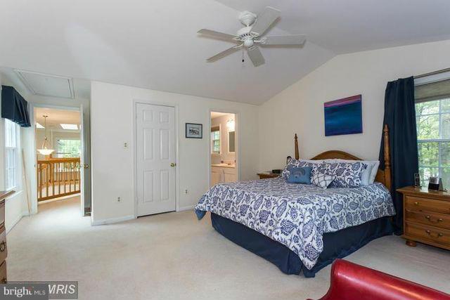 1500 Deer Point Way Reston, VA 20194 - Photo 16 of 26 a bedroom with a large bed and a chandelier