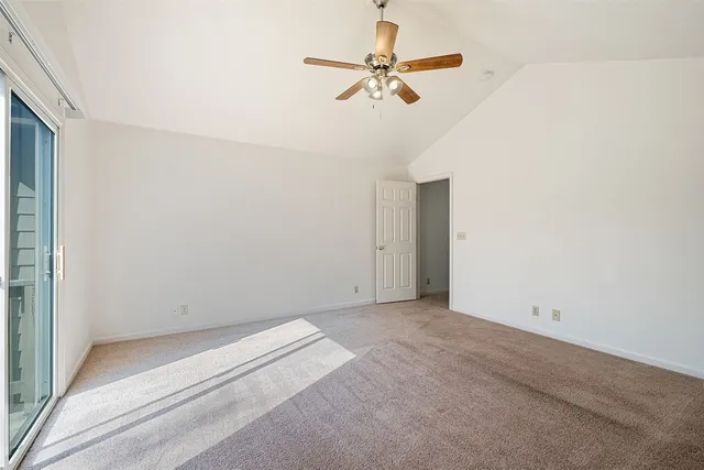 en empty room with ceiling fan and window