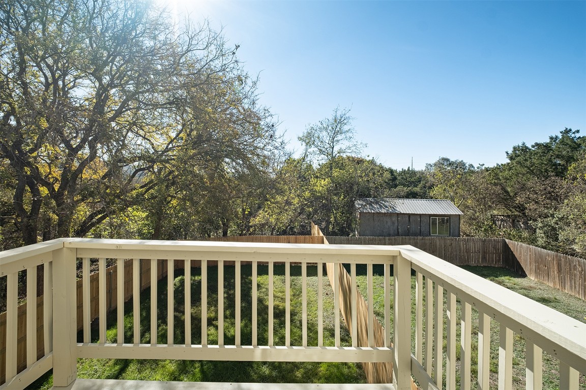 1003 Canyon Edge Drive, Unit B Austin, TX 78733 - Photo 16 of 25 a balcony with wooden floor and trees in the background