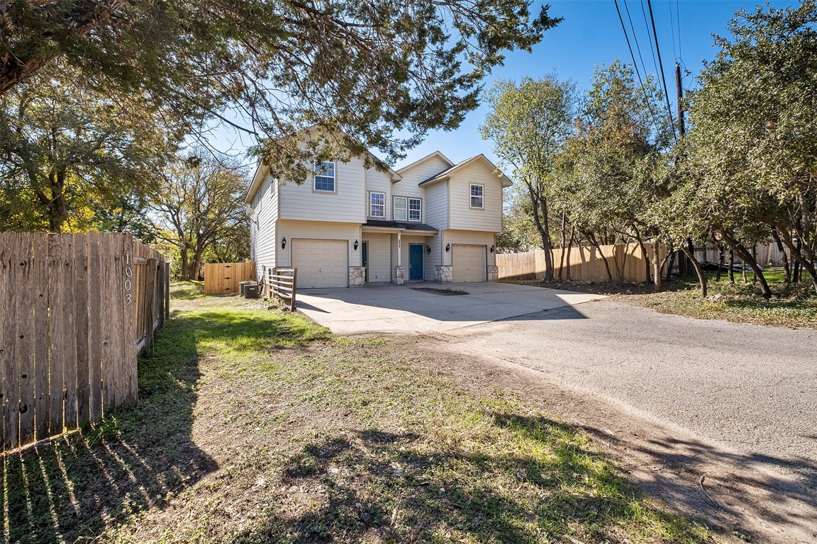 1003 Canyon Edge Drive, Unit B Austin, TX 78733 - Photo 2 of 25 a front view of a house with a yard and garage