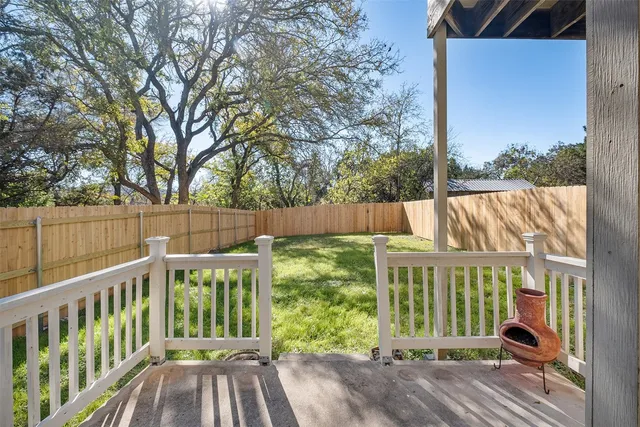 a view of a house with a small yard and wooden fence
