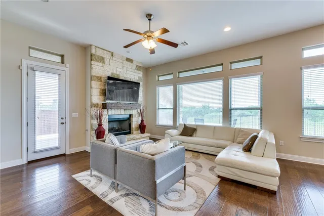 a living room with furniture large window and wooden floor