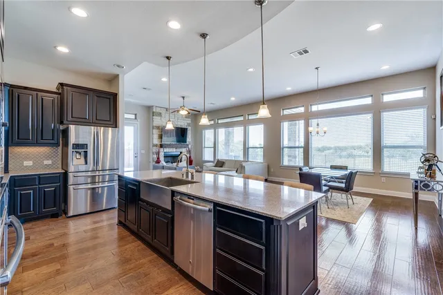 a large kitchen with stainless steel appliances granite countertop a stove and large center island