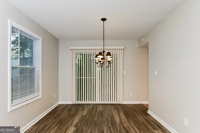 a view of a hallway with wooden floor and a window