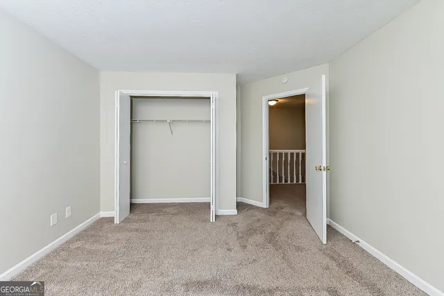 an empty room with closet and a bathroom