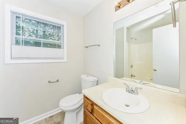 a bathroom with a sink a toilet and a mirror