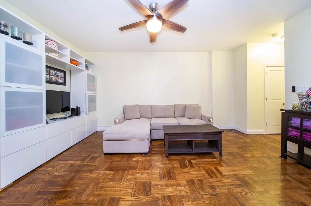 61-05 39th Avenue, Unit G3 Queens, NY 11377 - Photo 3 of 8 Living room featuring dark parquet flooring and ceiling fan