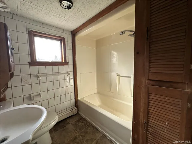 a bathroom with a tub a sink and a shower