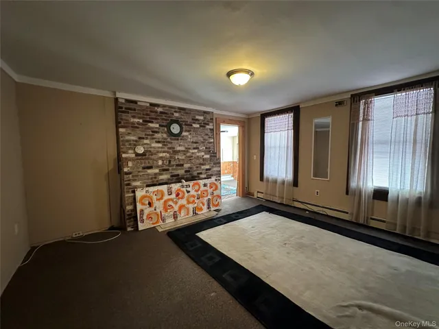 a view of an empty room with windows & cabinet