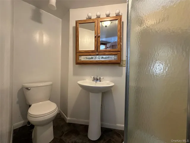 a bathroom with a toilet a sink and mirror