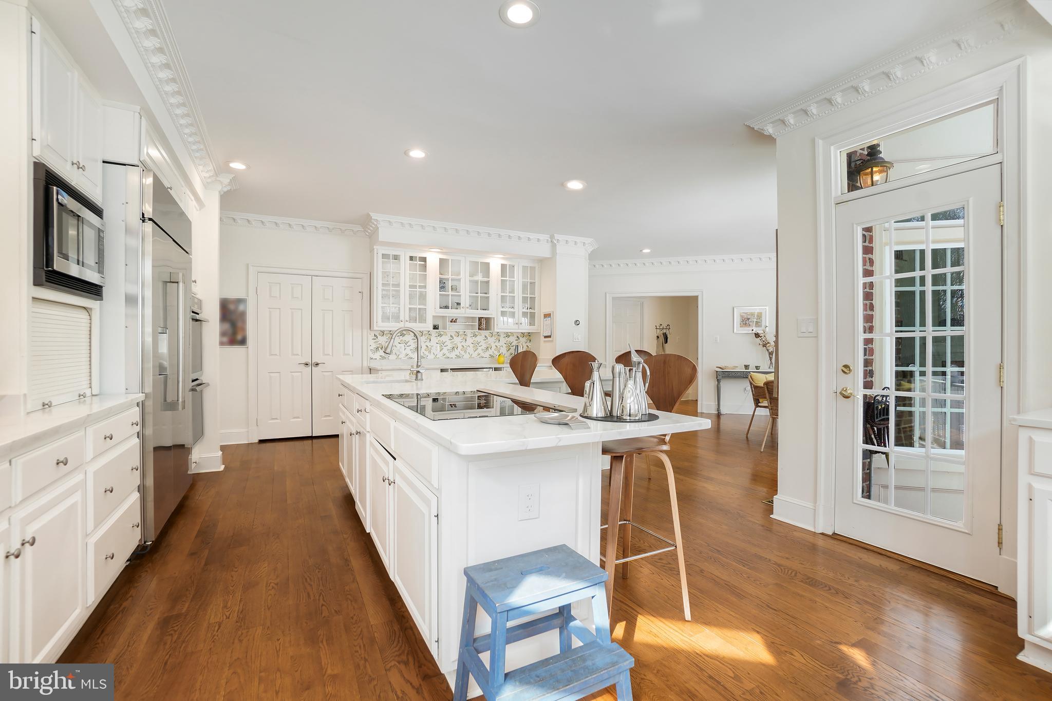 9646 Eagle Ridge Drive Bethesda, MD 20817 - Photo 15 of 75 a kitchen with stainless steel appliances kitchen island granite countertop a stove a sink a refrigerator and white cabinets with wooden floor