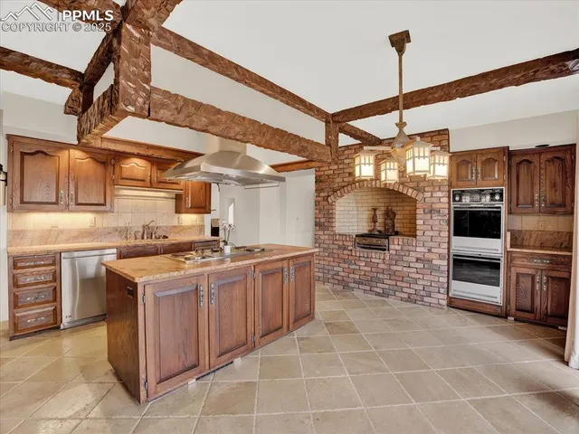 a kitchen with granite countertop a stove top oven microwave and refrigerator