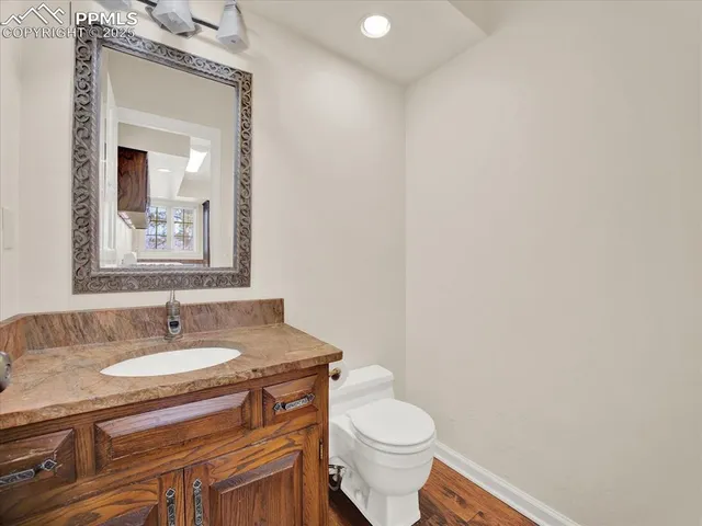 a bathroom with a granite countertop sink a toilet and mirror