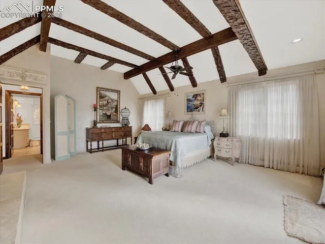 a spacious bedroom with a bed and a chandelier
