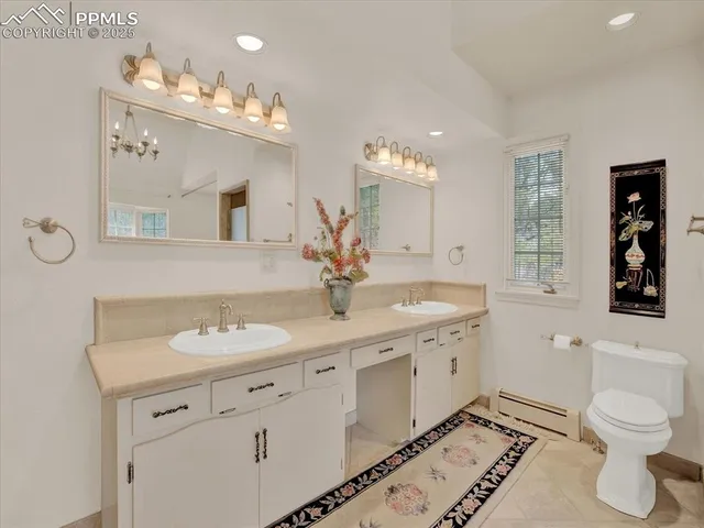 a bathroom with a granite countertop sink a toilet and a mirror